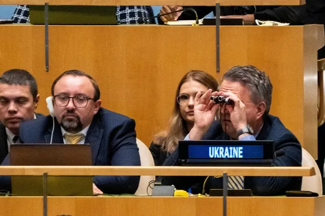 Ukrainian Ambassador to the U.N. Sergiy Kyslytsya scans the general assembly with binoculars prior to a vote on the resolution condemning the annexation of parts of Ukraine by Russia, amid Russia's invasion of Ukraine, at the United Nations Headquarters in New York City, New York, U.S., October 12, 2022. (Photo by David “Dee” Delgado/Reuters)