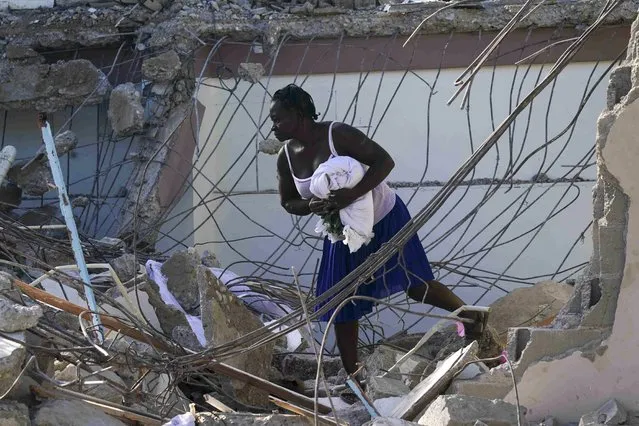 A woman walks through the rubble of a collapsed hotel in Les Cayes, Haiti, Monday, August 16, 2021, two days after a 7.2-magnitude earthquake struck the southwestern part of the country. (Photo by Fernando Llano/AP Photo)