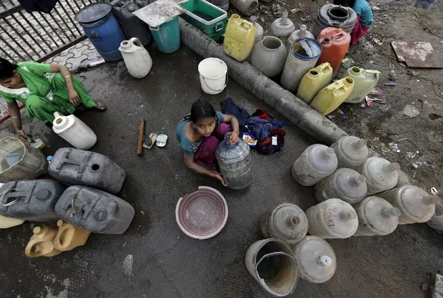 A girl waits to fill water in her containers from a municipal tap in New Delhi, India, February 21, 2016. (Photo by Anindito Mukherjee/Reuters)