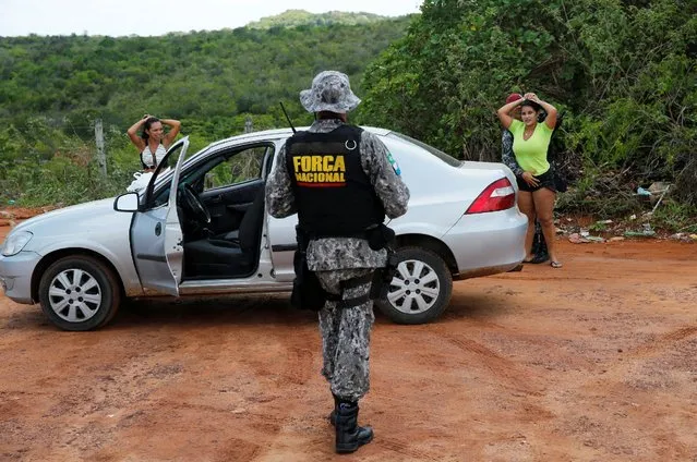 Military police search relatives of inmates as part of an operation to look for items that are on the prison contraband list during to an uprising in front of Alcacuz prison in Natal, Rio Grande do Norte state, Brazil, January 23, 2017. (Photo by Nacho Doce/Reuters)