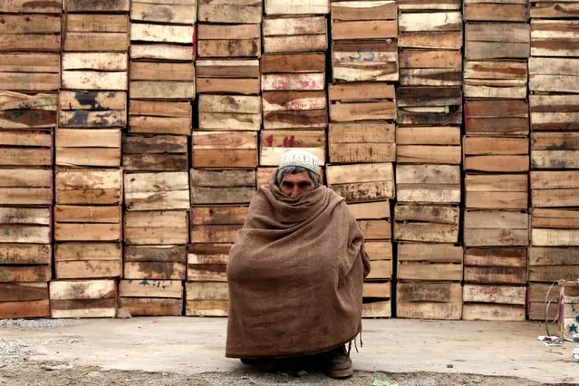 A man covers himself in a traditional shawl in a street during cold weather and dense fog conditions in Peshawar, Pakistan, 04 January 2024. According to a Pakistan Meteorological Department (PMD) forecast, cold and dry weather is expected to persist over the next few days in most plain areas of the country, with dense fog likely to persist in areas of Punjab and Sindh provinces. (Photo by Bilawal Arbab/EPA/EFE)