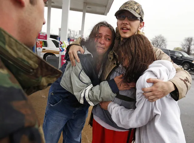 Dacia Winters, left, embraces Ryan Ficca, center, and Stormy Winters after they were evacuated in a Louisiana National Guard high water vehicle from rising floodwaters in Bossier Parish, La., Thursday, March 10, 2016. Heavy rain has forced evacuations and caused flash flooding for more than a day. (Photo by Gerald Herbert/AP Photo)