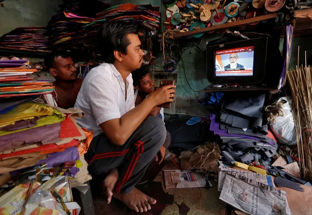 Men watch Prime Minister Narendra Modi addressing to the nation, on a TV screen inside their shop in Kolkata, India, March 27, 2019. (Photo by Rupak De Chowdhuri/Reuters)