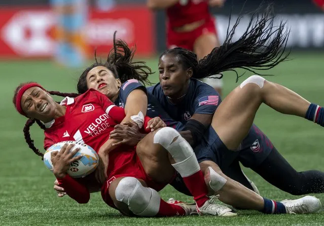 Canada's Charity Williams, left, is tackled by United States' Alex Sedrick, center, and Naya Tapper during a Vancouver Sevens women's rugby match Saturday, February 24, 2024, in Vancouver, British Columbia. (Photo by Ethan Cairns/The Canadian Press via AP Photo)