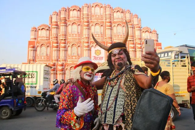 Artists take a selfie in front of the replica of Hawa Mahal, installed in the city on the occasion of Diwali Festival at Choti Chaupar, in Jaipur, Rajasthan, India on Wednesday, November 03, 2021.(Photo by Vishal Bhatnagar/NurPhoto via Getty Images)