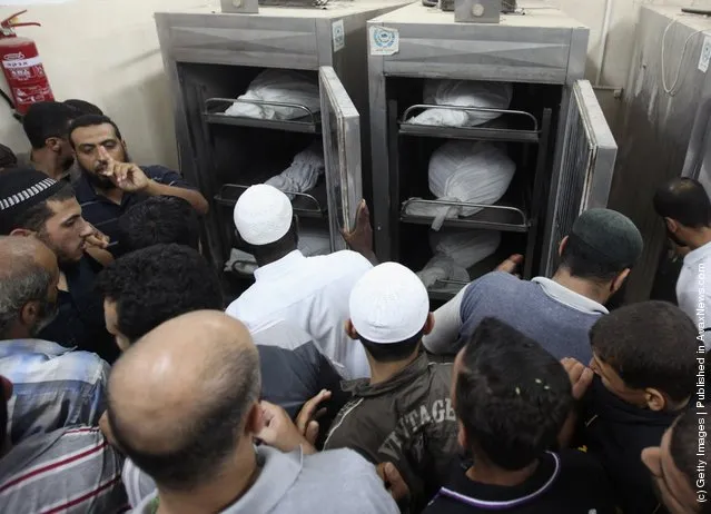 Palestinians stand in the morgue next to the bodies of six militants killed in an Israeli airstrike