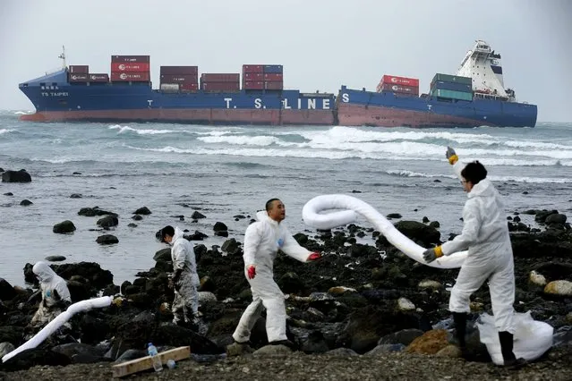 Workers erect spill booms to collect oil on the shore spilled from a Taiwanese container ship owned by the shipping company T.S. Lines off the shore of Shimen, New Taipei City, Taiwan, 26 March 2016. The 15,487-ton ship ran aground in a storm about 300 meters from the shore while it was sailing from Hong Kong to Keelung Port in Taiwan on 10 March. The ship carries about 407 tons of fuel and FW40 tons of kerosene, about half of which has been pumped out. (Photo by Ritchie B. Tongo/EPA)