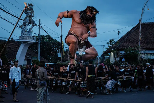 Indonesian Hindus carry Ogoh-ogoh, a statue symbolising an evil spirit, before a parade on the eve of Nyepi, in Klungkung, Bali on March 10, 2024. Hindus in Indonesia, the world's largest Muslim-populated nation, will celebrate the “Day of Silence”, locally known as Nyepi, which marks the new year in the Balinese Hindu calendar, on March 11. (Photo by Yasuyoshi Chiba/AFP Photo)