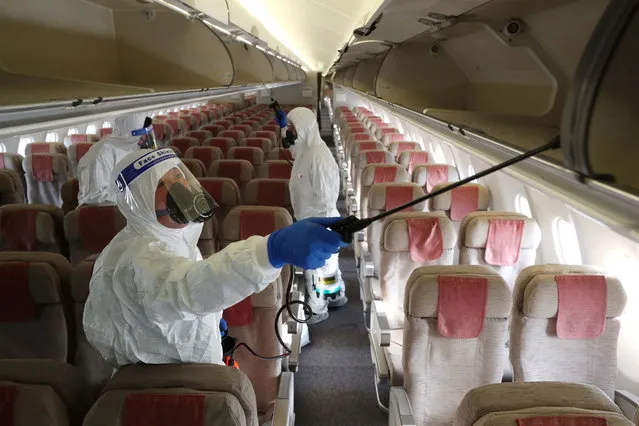 Quarantine officials disinfect the cabin of an Asiana Airlines plane at Incheon International Airport, in Incheon, South Korea, 09 December 2021, amid mounting concerns about the influx of the omicron variant. (Photo by Yonhap/EPA/EFE)