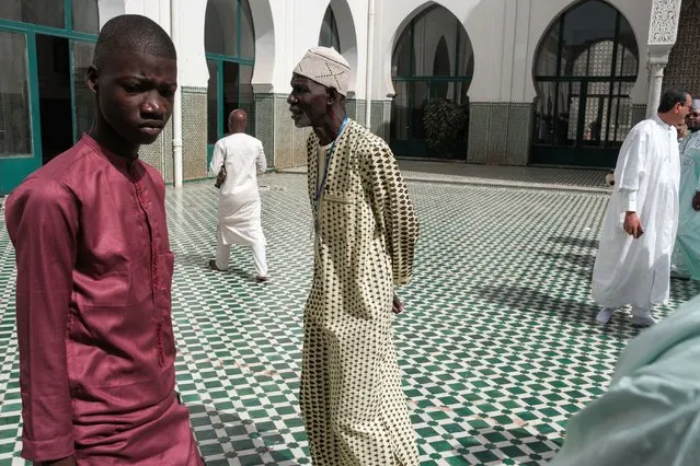People dressed in traditional clothes walk around the courtyard ahead of the start of the Eid al-Fitr festival, marking the end of the holy month of Ramadan, locally known as Korite, at the Dakar Grand Mosque in Dakar on April 10, 2024. (Photo by Guy Peterson/AFP Photo)