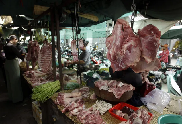 In this Thursday, May 16, 2019, photo, pork hangs for sale at the Phsar Kandal market in Phnom Penh, Cambodia. Pork lovers worldwide are wincing at prices that have jumped by up to 40 percent as China’s struggle to stamp out African swine fever in its vast pig herds sends shockwaves through global meat markets. Potential shortages are a more serious concern in places such as Cambodia where pork is the only meat many families can afford. (Photo by Heng Sinith/AP Photo)