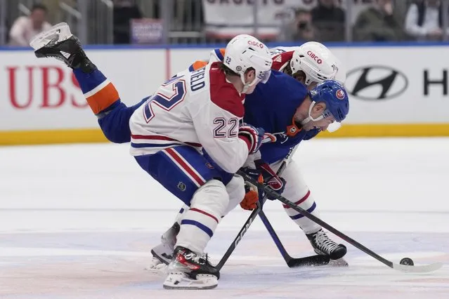 New York Islanders' Adam Pelech, center, is squeezed by Montreal Canadiens' Cole Caufield, left, and Jake Evans during the second period of an NHL hockey game Thursday, April 11, 2024, in Elmont, N.Y. (Photo by Seth Wenig/AP Photo)