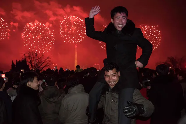 A man poses for a photo as people watch a fireworks display near the Taedong river, on the occasion of the 75th anniversary of the birth of Kim Jong-Il, in central Pyongyang on February 16, 2017. North Korean newlyweds, soldiers and children lined up to laud their country's rulers on February 16, the birthday of the late Kim Jong-Il, father of both the current leader and the exiled renegade assassinated in Malaysia this week. (Photo by Ed Jones/AFP Photo)