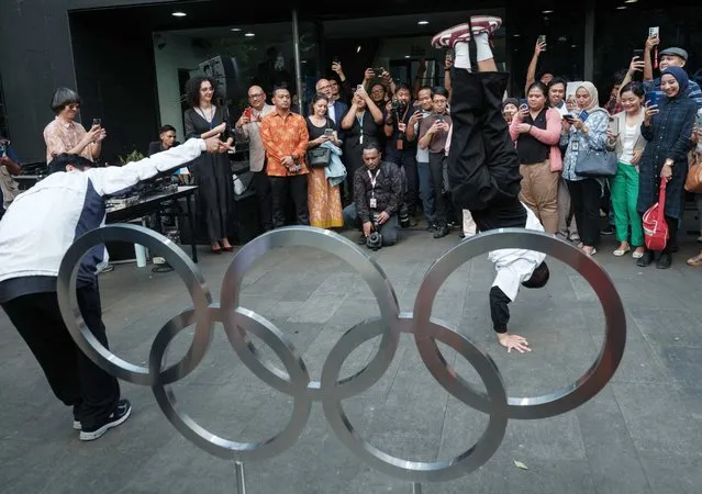 Indonesian breakdancers perform in front of the Olympic rings during the opening of the AFP photo exhibition “Road to Paris 2024” in Jakarta on April 25, 2024, ahead of the Paris 2024 Olympic Games. (Photo by Yasuyoshi Chiba/AFP Photo)