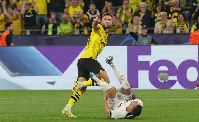 Borussia's Niclas Fullkrug (up) celebrates after scoring for the 1-0 lead against PSG, as PSG's Lucas Hernandez (down) falls after their interaction during the UEFA Champions League semi final, 1st leg match between Borussia Dortmund and Paris Saint-Germain in Dortmund, Germany, 01 May 2024. (pHOTO BY Friedemann Vogel/EPA)