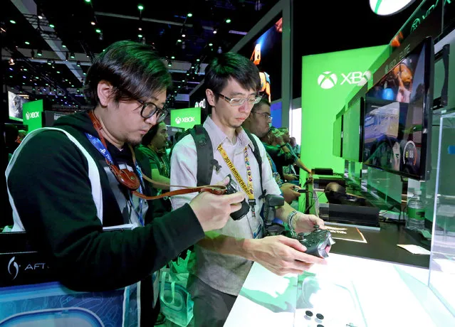 E3 2015 attendees interact with the Xbox Elite Wireless Controller at the Xbox booth at E3 in Los Angeles on Tuesday, June 16, 2015. (Photo by Casey Rodgers/Invision for Microsoft/AP Images)