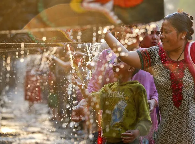 Hindu devotees shower in water pouring from 22 waterspouts during Balaju Purnima, also known as the full moon festival, in Katmandu, Nepal, 22 April 2016. Hundreds of devotees gathered to take a ritual bath and pay reverence to the waterspouts in hopes of being granted protection from illness, and a better life. (Photo by Narendra Shrestha/EPA)
