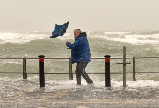 Someone struggles with an umbrella on Mudeford Quay seafront in Dorset, UK during storm Nelson on March 28, 2024. (Photo by Steve Hogan/Picture Exclusive)
