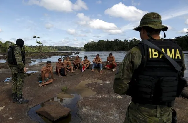 Gold prospectors are detained by agents of Brazil’s environmental agency on the Uraricoera River during an operation against illegal gold mining on indigenous land, in the heart of the Amazon rainforest, in Roraima state, Brazil April 16, 2016. (Photo by Bruno Kelly/Reuters)