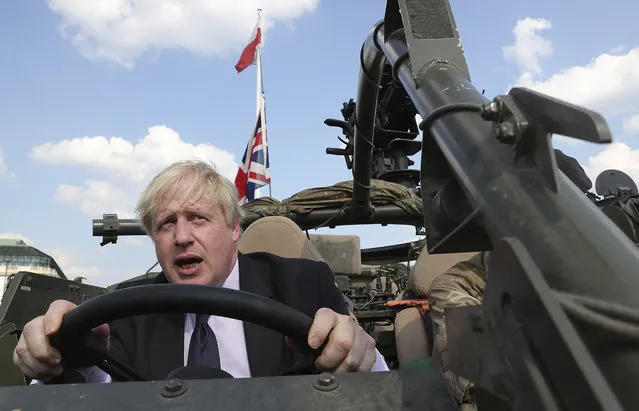 In this Thursday, June 21, 2018 file photo Britain's Foreign Secretary Boris Johnson talks to a British armed forces serviceman based in Orzysz, in northeastern Poland, during a ceremony at the Tomb of the Unknown Soldier and following talks on security with his Polish counterpart Jacek Czaputowicz in Warsaw, Poland. Boris Johnson aspires to be a modern-day Winston Churchill. Critics fear he's a British Donald Trump. Johnson won the contest to lead the governing Conservative Party on Tuesday July 23, 2019, and is set to be asked Wednesday by Queen Elizabeth II to become Britain's next prime minister. (Photo by Czarek Sokolowski/AP Photo/File)