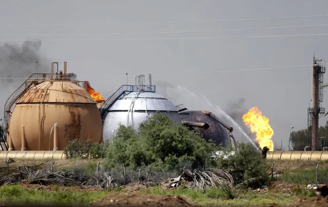 Iraqi firefighters try to extinguish a fire at a natural gas plant in Taji, 12 miles (20 kilometers) north of Baghdad, Iraq, Sunday, May 15, 2016. The Islamic State group launched a coordinated assault Sunday on a natural gas plant north of the capital that killed more than a dozen people, according to Iraqi officials. (Photo by AP Photo)