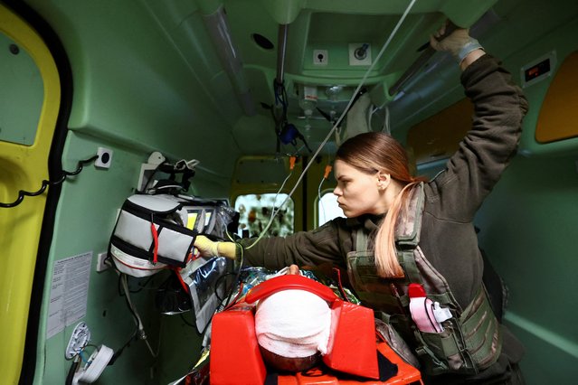 Paramedic Marjana, an intensive care medic of Pirogov First Volunteer Mobile Hospital (PFVMH), treats a wounded Ukrainian service member in an ambulance, transporting him from a field hospital near the frontline of Bakhmut to a specialist trauma hospital in the city of Kramatorsk, during Russia's ongoing invasion of Ukraine on March 3, 2023. (Photo by Lisi Niesner/Reuters)