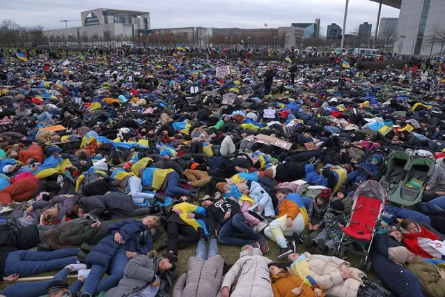 Protesters, most of them Ukrainians and many of them refugees, lie down during a demonstration to symbolise the murdered civilians of the current Russian war in Ukraine as the Chancellery stands behind on April 06, 2022 in Berlin, Germany. Protest leaders called for a full embargo against Russia and an end to civilian deaths in the war. Meanwhile the numbers of confirmed civilian dead in towns north of Kyiv like Bucha, Irpin and Hostomel are continuing to rise in the wake of the Russian military retreat following their occupation of the area. (Photo by Sean Gallup/Getty Images)