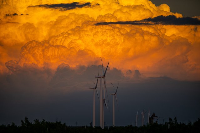 Cumulonimbus clouds rise behind wind turbines on September 19, 2023 in Big Spring, Texas. (Photo by Brandon Bell/Getty Images)