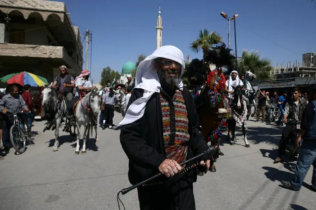 A man wearing traditional clothes takes part in a parade for Arabian horses in the rebel held area of Damascus's Eastern Ghouta suburbs, Syria May 30, 2016. (Photo by Bassam Khabieh/Reuters)
