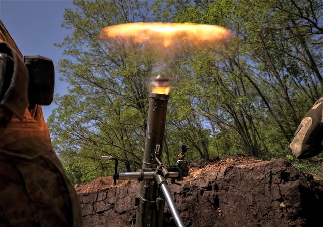 Ukrainian service members from a 28th separate mechanised brigade named after the Knights of the Winter Campaign of the Armed Forces of Ukraine, fire a mortar at their positions at a front line, amid Russia's attack on Ukraine, near the city of Bakhmut in Donetsk region, Ukraine on May 18, 2023. (Photo by Sofiia Gatilova/Reuters)