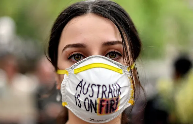 A demonstrator with a mask attends a climate protest rally in Sydney on December 11, 2019. Up to 20,000 protesters rallied in Sydney on December 11 demanding urgent climate action from Australia's government, as bushfire smoke choking the city caused health problems to spike. (Photo by Saeed Khan/AFP Photo)
