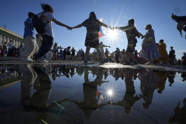 People dance during a round dance flashmob at the Palace Square in St. Petersburg, Russia, Thursday, August 15, 2024. (Photo by Dmitri Lovetsky/AP Photo)