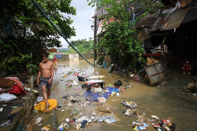 A resident walks past debris of trash swept by flood waters following heavy rains brought about by Tropical Storm Yagi at a village in Cainta town, Rizal province, East of Manila on September 3, 2024. Floods and landslides killed 11 people after a fierce tropical storm dumped heavy rain on the Philippines for a second day, officials said September 2. (Photo by Ted Aljibe/AFP Photo)