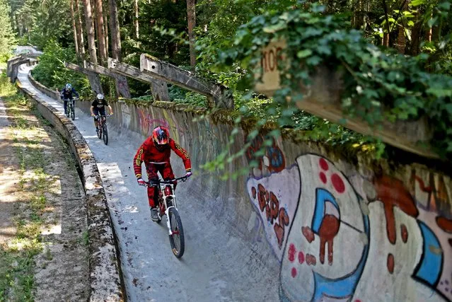 Downhill bikers Kemal Mulic (R-L), Tarik Hadzic and Kamer Kolar train on the disused bobsled track from the 1984 Sarajevo Winter Olympics on Trebevic mountain near Sarajevo, Bosnia and Herzegovina, August 8, 2015. (Photo by Dado Ruvic/Reuters)