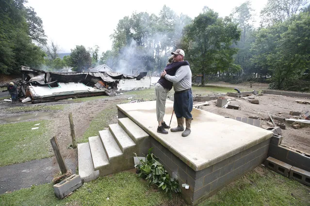 Jimmy Scott gets a hug from Anna May Watson, left, as they clean up from severe flooding in White Sulphur Springs, W. Va., Friday, June 24, 2016. Scott lost his home to the flood and a fire that consumed his and the homes of several relatives. (Photo by Steve Helber/AP Photo)