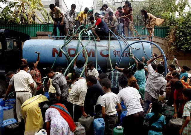 People collect water from a government tanker at a slum in New Delhi, India, June 18, 2012