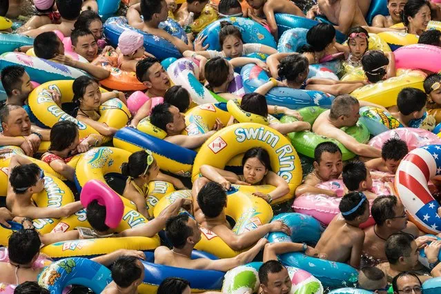 Chinese tourists with swim rings enjoy swimming in the lake called 'Dead sea of China' in a resort of Suining city, southwestern China's Sichuan province, 22 July 2017. More than 8,000 tourists gathered enjoy the water during hot weather. (Photo by Lola Levan/EPA)