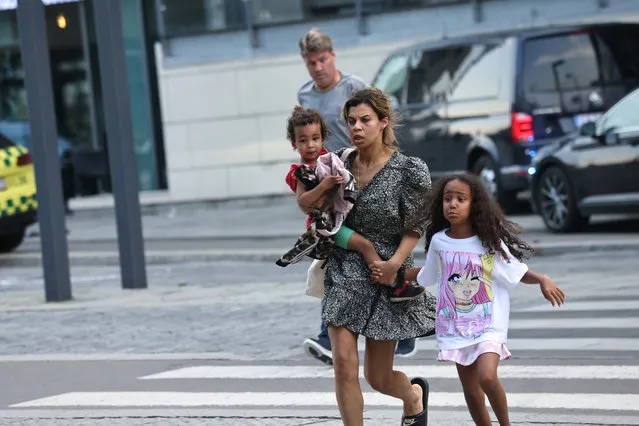 A woman and children flee the Field's shopping center after a shooting, in Copenhagen, Denmark, Sunday, July 3, 2022. (Photo by Olafur Steinar Gestsson/Ritzau Scanpix via AP Photo)