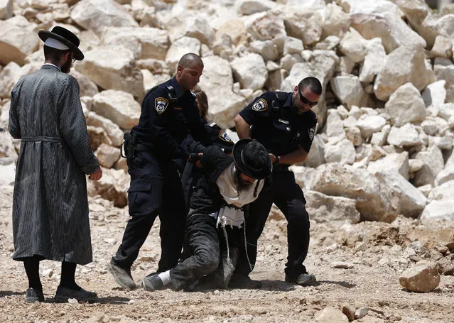 An Ultra-Orthodox Jewish man is arrested by Israeli  policemen during a demonstration against the building of new residence units at a site believed to be housing ancient Jewish graves, in down-town Jerusalem, on August 17, 2015. (Photo by Ahmad Gharabli/AFP Photo)