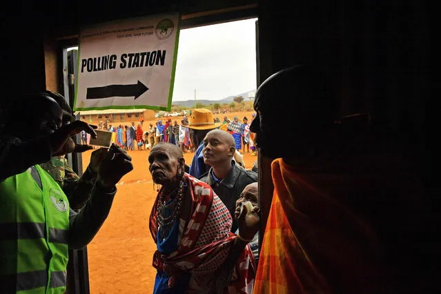 Naseremo Ene Kiurei, an elderly Maasai woman has her ID card checked at a polling station in Saikeri, Kajiado West County on August 8, 2017. Kenyans began voting in general elections headlined by a too-close-to-call battle between incumbent Uhuru Kenyatta and his rival Raila Odinga that has sent tensions soaring in east Africa's richest economy. (Photo by Carl de Souza/AFP Photo)