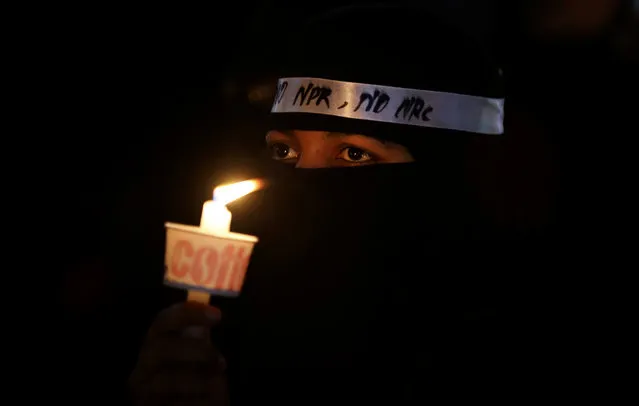 An Indian Muslim woman holds a candle during a protest against a new citizenship law that opponents say threatens India's secular identity in Bangalore, India, Friday, February 14, 2020. The new citizenship law fast-tracks naturalization for non-Muslim migrants from neighboring Pakistan, Bangladesh and Afghanistan who are living in the country illegally. (Photo by Aijaz Rahi/AP Photo)