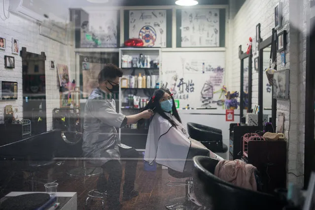 A barber and a customer wear protective masks in a barbershop on March 03, 2020 in Shanghai, China. Since the outbreak began in December last year, more than 80,000 cases have been confirmed in China, with the death toll rising to more than 2,900. As of today, the number of cases of new coronavirus COVID-19 being treated in China dropped to approximately 30,000 in China, in what the World Health Organization (WHO) declared to raises coronavirus threat assessment to “very high” across the world by the end of February. (Photo by Yifan Ding/Getty Images)