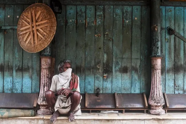 A labourer sits next to closed shops as he waits for daily work during a government-imposed nationwide lockdown as a preventive measure against the COVID-19 coronavirus, in Kolkata on April 22, 2020. (Photo by Dibyangshu Sarkar/AFP Photo)