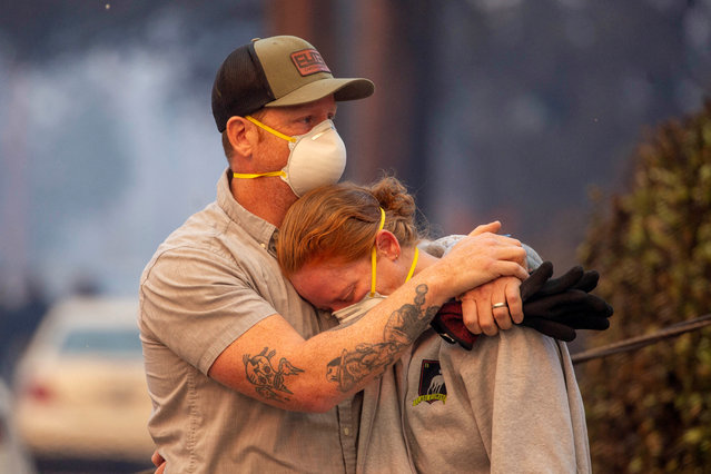 People embrace as they return to the home after it has been burned down by wildfires in the Los Angeles area, at the Eaton Fire in Altadena, California, on January 9, 2025. (Photo by Ringo Chiu/Reuters)