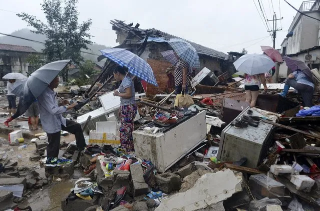 Residents look for their belongings among the debris of collapsed houses destroyed by floods caused by Typhoon Soudelor in Huoshan county, Anhui province, China, August 10, 2015. (Photo by Reuters/Stringer)