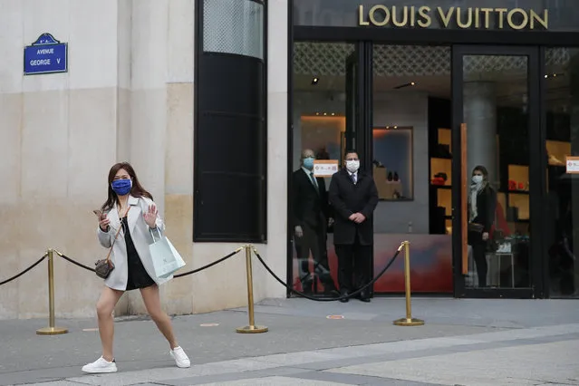 A woman gestures in front of a luxury shop that opens Monday, May 11, 2020 in Paris. he French began leaving their homes and apartments for the first time in two months without permission slips as the country cautiously lifted its lockdown. Clothing stores, coiffures and other businesses large and small were reopening on Monday – with strict precautions to keep the coronavirus at bay. (Photo by Francois Mori/AP Photo)
