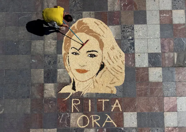 Kosovo artist Alkent Pozhegu works on the final touches of British singer Rita Ora portrait made with wheat, rice, sunflower seeds, corn, lentils in Tirana, Albania on September 6, 2022. (Photo by Florion Goga/Reuters)