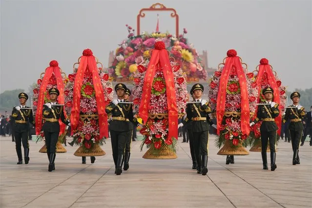 Members of a Chinese honor guard carry floral wreaths during a commemorative ceremony to pay tribute to the Monument to the People's Heroes at Tiananmen Square on the Martyrs' Day on September 30, 2022 in Beijing, China. (Photo by VCG/VCG via Getty Images)