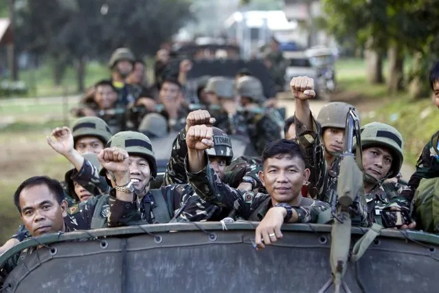 Filipino soldiers on a military truck gesture during Philippine President Rodrigo Duterte's visit (unseen) to the volatile island of Sulu, southern Philippines, 12 August 2016. According to local news, President Rodrigo Duterte flew to Jolo, Sulu Island, to meet military commanders ordering the Philippine army to destroy the violent Abu Sayyaf militant group before the Philippines gets “contaminated by Islamic State”. The rebel group has been known for notorious extortion, kidnappings, and bombings. They are still holding foreign hostages from Norway, the Netherlands, Indonesians, and Malaysians. (Photo by Ben Hajan/EPA)