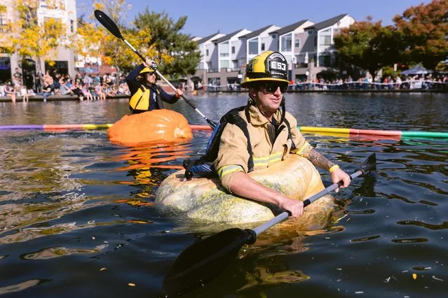 Garret Cox, of Tualatin Valley Fire & Rescue, prepares to paddle in the first responder race during the West Coast Giant Pumpkin Regatta in Tualatin, Oregon, on October 16, 2022. Since 2004, costumed characters in giant pumpkins compete in a series of races in Tualatin Lake. (Photo by Wesley Lapointe/AFP Photo)